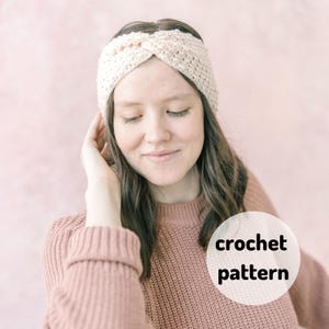 Pode incluir: Uma mulher usando uma faixa de cabeça de crochê branca com um design trançado. A faixa é usada sobre a testa e cobre as orelhas. A mulher está usando um suéter rosa e tem cabelo castanho longo. O texto "crochet pattern" está escrito em um círculo branco no lado direito da imagem.