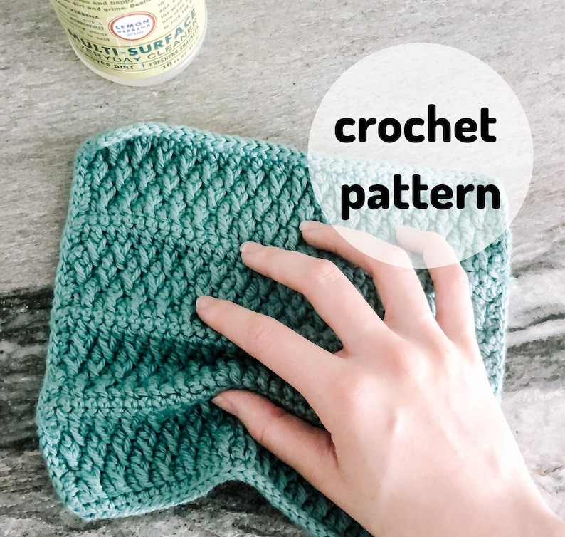 May include: A teal crochet pattern is displayed, with the words "crochet pattern" overlaid on the image. The textured fabric is being held by a hand. The image is shot from above.