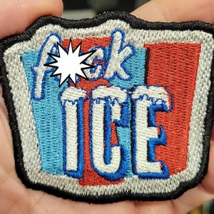 May include: Embroidered patch with the words "f*ck ICE" in blue and white, with a red background. The patch has a black border and a white starburst graphic. The patch is rectangular with rounded corners.