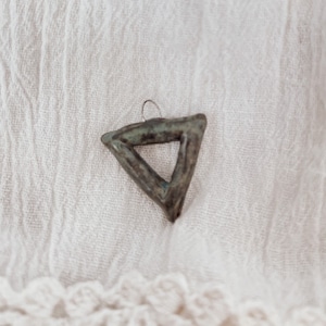 May include: A dark green and brown ceramic triangle pendant with a silver loop at the top.