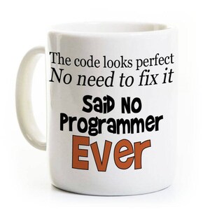 May include: White ceramic mug with a black and orange design. The mug reads "The code looks perfect. No need to fix it. Said No Programmer Ever."