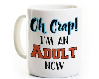 May include: White ceramic mug with the text "Oh Crap! I'm an Adult Now" in black, blue, and orange lettering. The mug has a curved handle and is set against a white background.