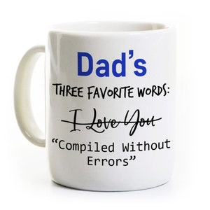May include: White ceramic coffee mug with a blue inscription that reads "Dad's Three Favorite Words: I Love You "Compiled Without Errors""