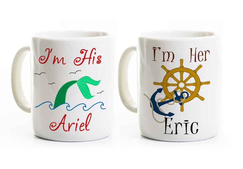 Puede incluir: Dos tazas de cer&aacute;mica blanca con asas. La taza de la izquierda tiene una cola de sirena verde con el texto "I'm His Ariel". La taza de la derecha tiene un ancla azul y un tim&oacute;n dorado con el texto "I'm Her Eric".