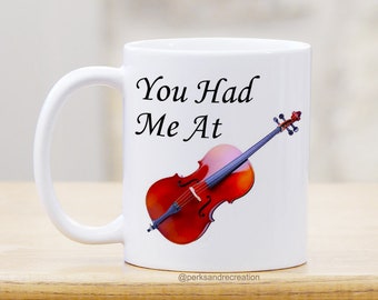 May include: White ceramic mug with a black handle. The mug has a red cello with a black and white design and the text "You Had Me At" printed on it. The mug has the text "@perksandrecreation" printed on the bottom.