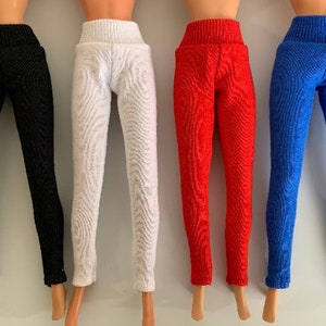 May include: Four pairs of doll-sized leggings in black, white, red, and blue.