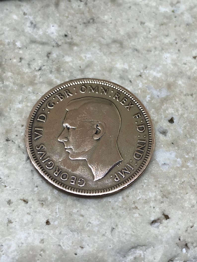 May include: A copper coin with the profile of King George VI and the inscription "GEORGIVS VI D:G:BR:OMN:REX F:D:IND:IMP:"