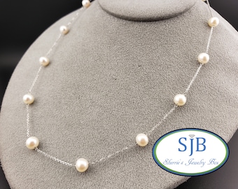 Könnte beinhalten: Eine zarte silberne Kettenkette mit weißen Perlen. Die Kette ist auf einem grauen Stoffhintergrund abgebildet. Der Text "SJB Sherrie's Jewelry Box" ist in der unteren rechten Ecke des Bildes sichtbar.