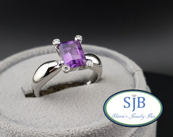 May include: A silver ring featuring a large, square-shaped amethyst gemstone surrounded by four smaller diamonds.