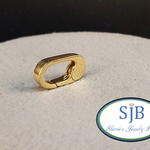 May include: Gold-toned metal clasp with a textured finish. The clasp is oval-shaped and has a spring-loaded mechanism.