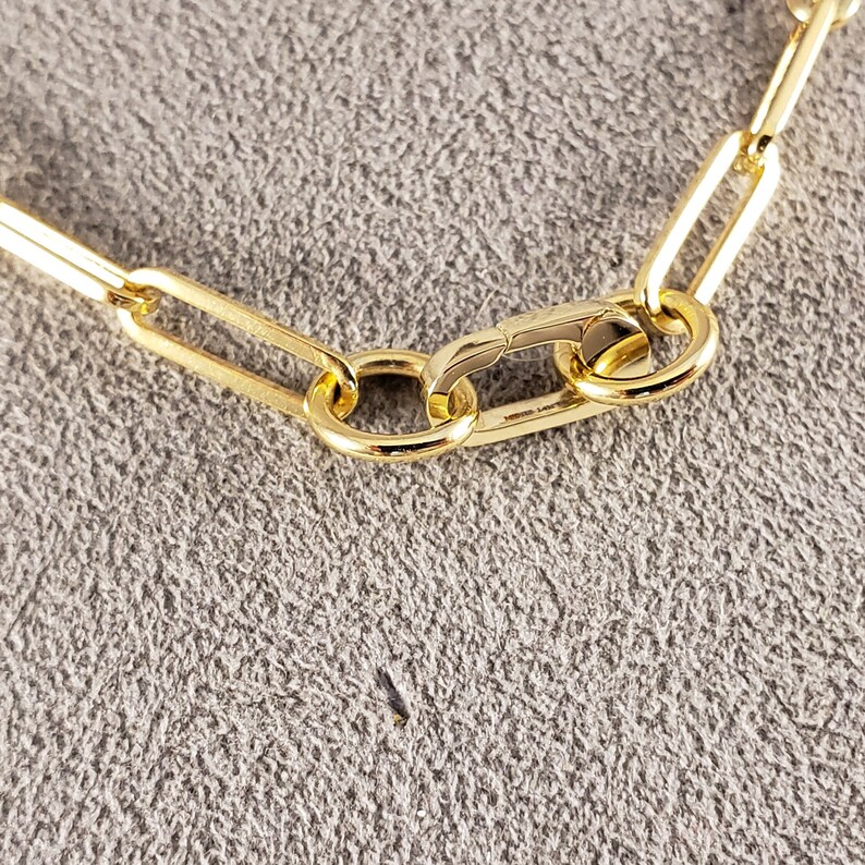 May include: Close-up of a gold chain necklace with a lobster clasp closure.