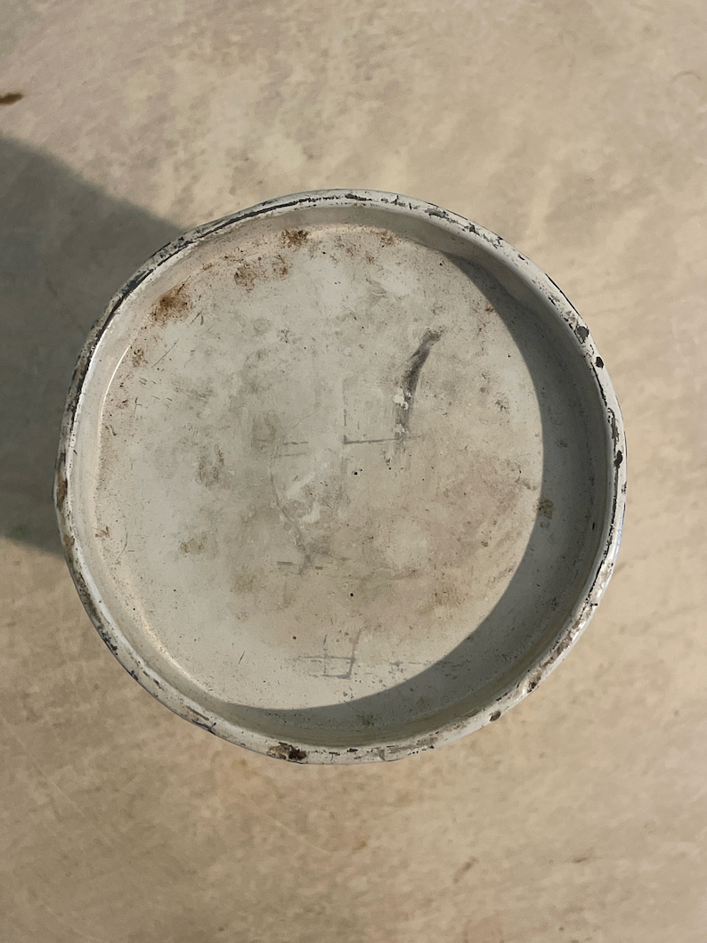 May include: White metal lid with a black rim. The lid has some scratches and marks on the surface.