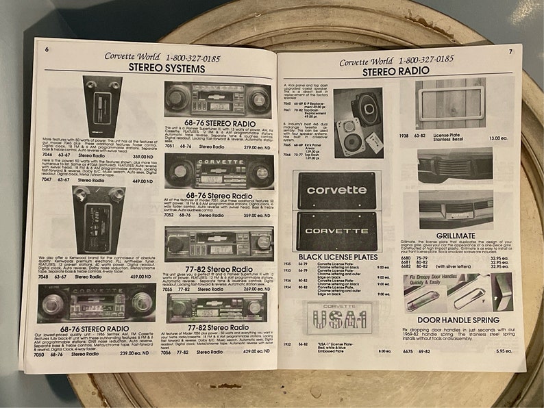 May include: A catalog page featuring Corvette parts and accessories. The page includes a variety of items, such as stereo systems, license plates, door handles, and grillmates. The catalog is from Corvette World and includes prices and part numbers.
