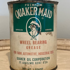 May include: A vintage tin can of Quaker Maid Premium Wheel Bearing Grease. The can is white with green and red accents. It says "Supertested" and "Guaranteed" on the front. The can is labeled for farm, automotive, and industrial uses. It is made by Quaker Oil Corporation in St. Louis, Missouri. The can is 1 pound.