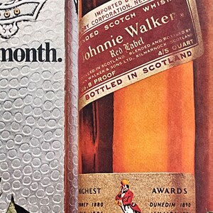 May include: A close-up of a Johnnie Walker Red Label Scotch Whisky bottle with a gold label. The label features the Johnnie Walker logo, the words "Red Label" and "Blended Scotch Whisky", and the text "Bottled in Scotland". The bottle is surrounded by a festive holiday background.