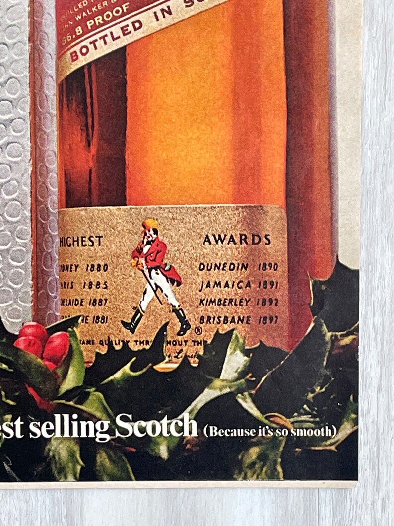 May include: A vintage advertisement for a bottle of Scotch whisky. The bottle is labeled with the brand name and the words "Bottled in Scotland". The ad also features a red-clad figure walking with a staff, and a list of awards won by the whisky. The text at the bottom of the ad reads "Highest selling Scotch (Because it's so smooth)".