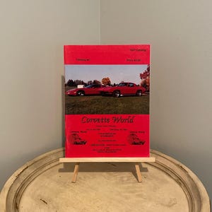 May include: A red Corvette World catalog from 1997, featuring a red Corvette on the cover. The catalog is priced at $3.00 and is catalog #8. The catalog advertises a phone number for Corvette World, 615-484-6210.