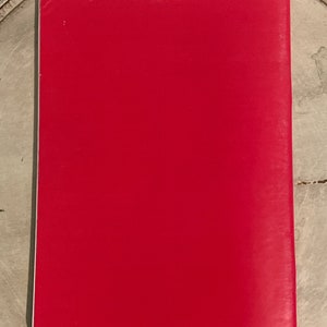 May include: A solid red book cover with a white border.