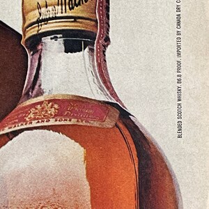 May include: A close-up of a brown glass bottle of blended Scotch whisky with a gold cap that says "Johnnie Walker" on it. The label is red and gold and says "Blended Scotch Whisky, 86.8 Proof, Imported by Canada Dry Corp., N.Y., N.Y."