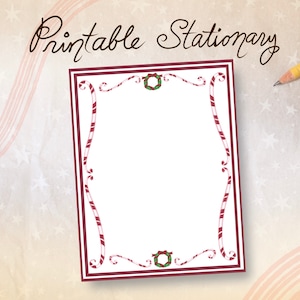 May include: Printable stationery with a white interior, framed by a burgundy border and candy cane-like accents. The top of the stationery features the text "Printable Stationery" in a cursive font. A pencil rests on the background.