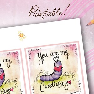 May include: A printable card with a watercolor illustration. The card features a purple caterpillar holding a red heart, with the text "You are my CuddleBug." The word "Printable!" is written at the top.