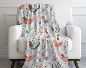May include: A white throw blanket with a repeating pattern of red, orange, and blue chickens and floral designs.