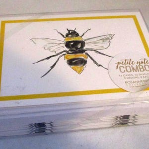 May include: A clear plastic box containing a set of petite note cards. Each card features a watercolor illustration of a bee with black and yellow stripes, set against a white background with a yellow border. The box has a sticker that says "petite note combo".