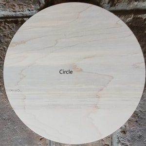 May include: A light-coloured, round wooden circle with visible wood grain. The word "Circle" is printed in black near the centre. The wood has a natural, unfinished appearance.