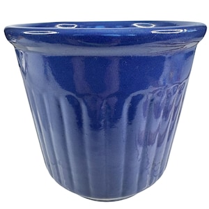 May include: A cobalt blue ceramic planter with a ribbed exterior. The planter has a slightly flared rim and a smooth, glossy finish. The interior is a darker shade of blue.