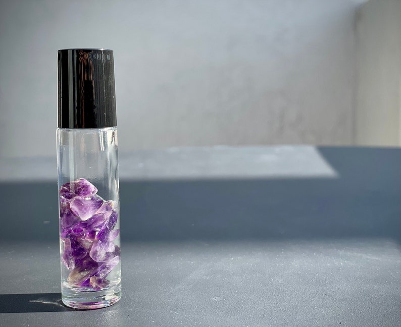LUST Pheromone body oil, infused with the soothing energy of Amethyst stones, enhances unisex attraction while providing the benefits of this renowned gemstone.