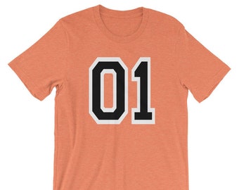 May include: A coral orange t-shirt with a black and white number "01" printed on the front.