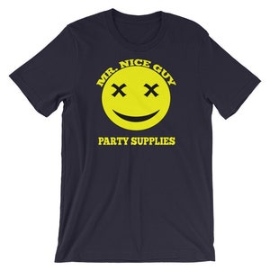 Op de afbeelding: Donkerblauw T-shirt met een gele smiley-afbeelding. De smiley heeft X'en voor ogen en de tekst "MR. NICE GUY" en "PARTY SUPPLIES" in geel.