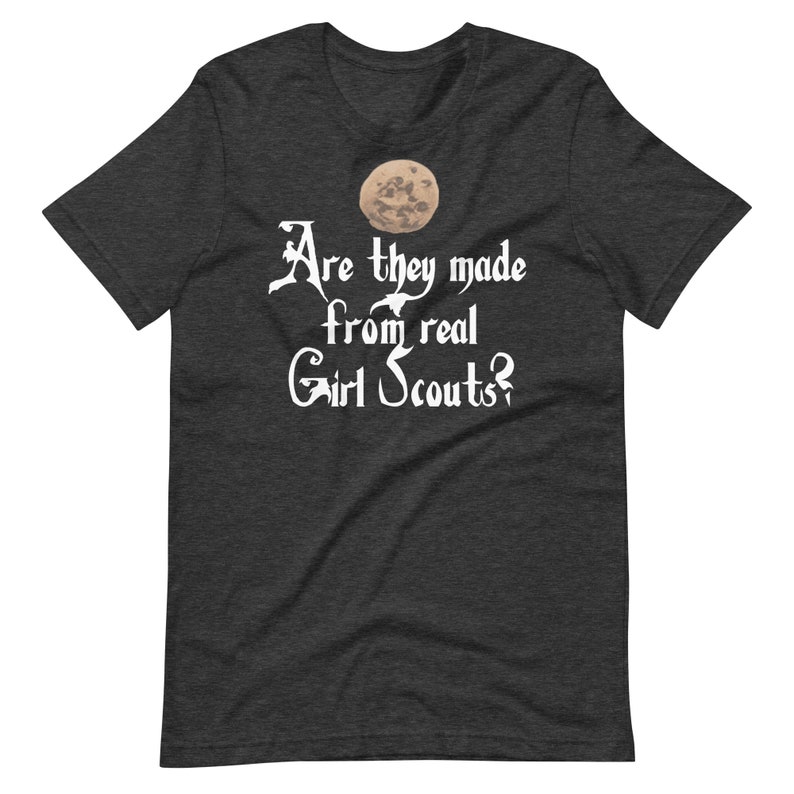 May include: Dark heather grey t-shirt with a white graphic of a moon and the text "Are they made from real Girl Scouts?"