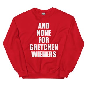 May include: A red sweatshirt with the text "AND NONE FOR GRETCHEN WIENERS" in white block letters. The sweatshirt has a crew neck and long sleeves. The Gildan brand label is visible at the back of the neck.