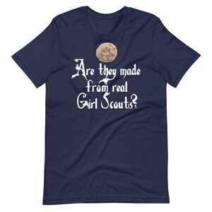 May include: Navy blue t-shirt with a white graphic of a moon and the text "Are they made from real Girl Scouts?"
