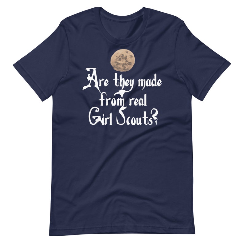 May include: Navy blue t-shirt with a white graphic of a moon and the text "Are they made from real Girl Scouts?"