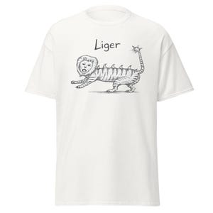 May include: White t-shirt featuring a black and white illustration of a liger, a hybrid animal. The design includes the word "Liger" above the illustration. The liger is depicted with a lion's head and a tiger's body.