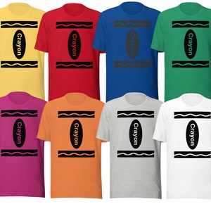 May include: Eight t-shirts featuring a crayon design. The shirts are in various colours: yellow, red, blue, green, pink, orange, grey, and white. Each shirt has the word "Crayon" printed on it.