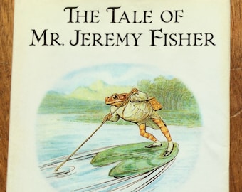 Peut inclure: Couverture du livre "L'Histoire de M. Jeremy Fisher" illustrant une grenouille en veste marron et pantalon vert pêchant sur un nénuphar. Le livre est de Beatrix Potter et est l'édition originale et autorisée avec de nouvelles reproductions en couleur. Le livre est publié par F. Warne & Co.
