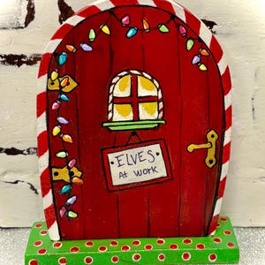 May include: A handmade wooden sign with the text "Welcome" in a playful font. The sign features a distressed white background and a dark brown frame, perfect for a front door or entryway. The sign measures approximately 12 inches wide and 6 inches tall.
