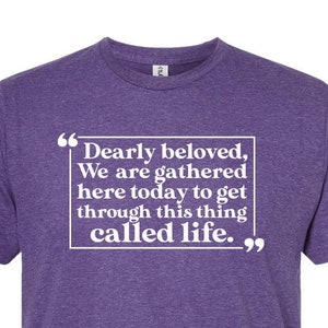 May include: Purple t-shirt with a white quote that reads "Dearly beloved, We are gathered here today to get through this thing called life."
