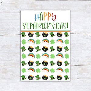 以下が含まれることがあります： カラフルな文字で「HAPPY ST. PATRICK'S DAY！」と書かれた白いカード。カードは、緑色のレプラコーンの帽子、黒い金の鍋、虹、緑色のクローバーで飾られています。デザインはお祝いと祝賀です。