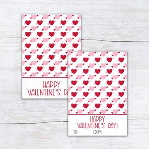 May include: Two printable Valentine's Day gift tags with a pink and red heart pattern. The text on the tags reads "Happy Valentine's Day!" with space to write "To:" and "From:".