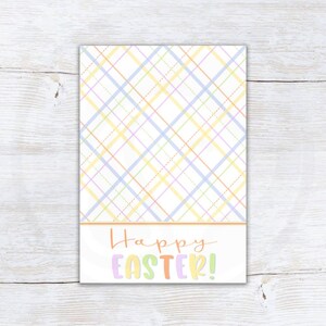 Puede incluir: Una tarjeta rectangular con un patrón de cuadros pastel en amarillo, azul y lavanda. La sección inferior presenta las palabras "Happy EASTER!" en letras coloridas y juguetonas. La tarjeta está sobre un fondo de vetas de madera clara.