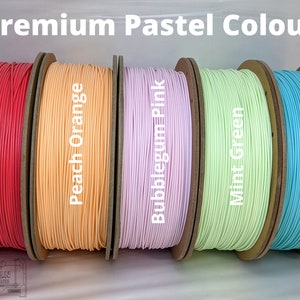 K&ouml;nnte beinhalten: Spulen mit farbenfrohem 3D-Druckfilament in Pastellt&ouml;nen: Wassermelonenrot, Pfirsichorange, Bubblegum-Pink, Mintgr&uuml;n und Arctic Teal. Der Text "Premium Pastel Colours" ist &uuml;ber den Spulen zu sehen.