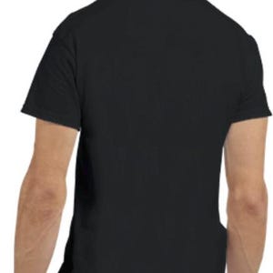 May include: A plain black short-sleeved t-shirt. The shirt is made of a soft material and has a crew neck. The back of the shirt is visible, with the shoulders and upper back in focus. A simple, everyday garment.