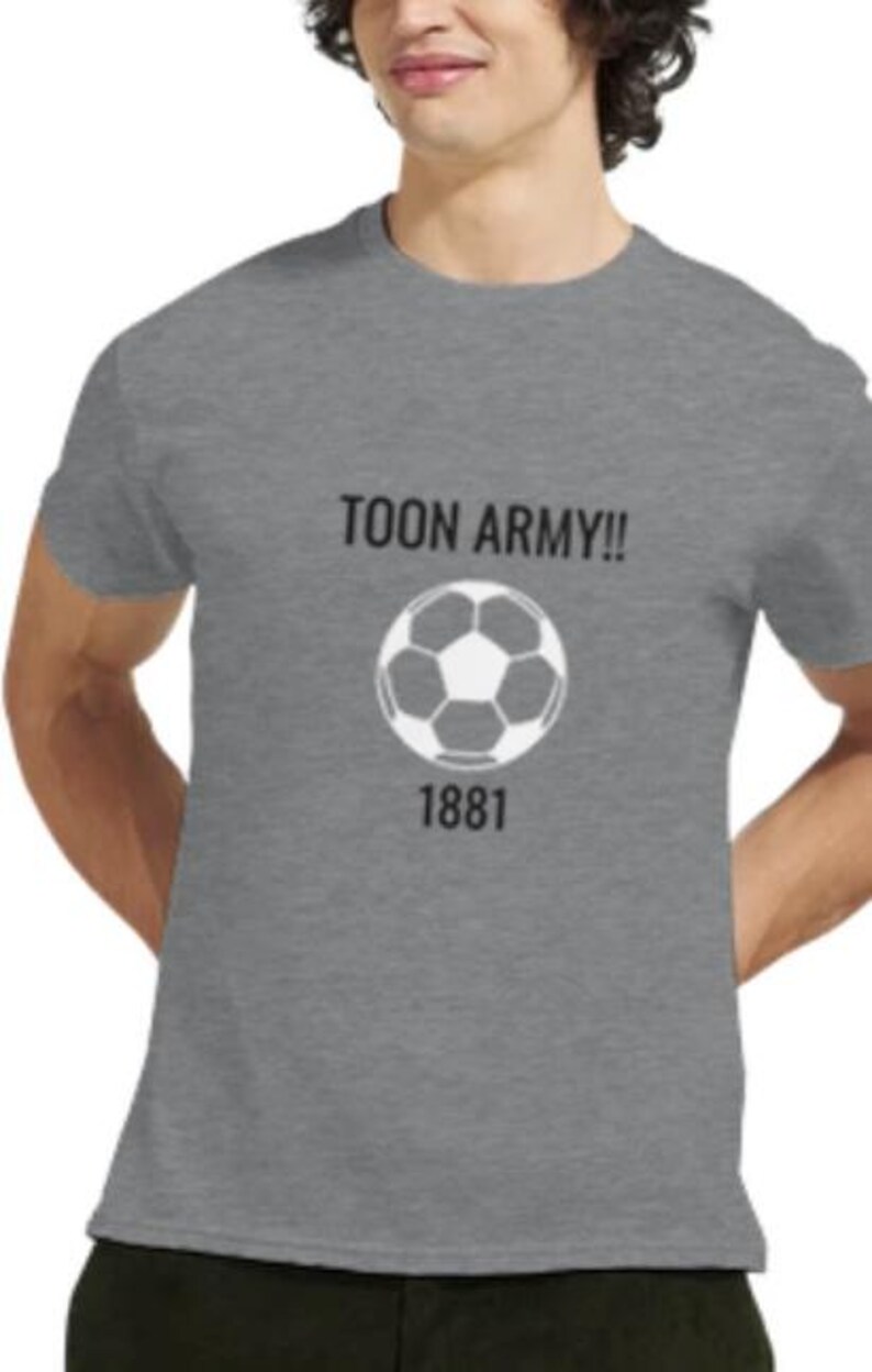 May include: Grey crew neck t-shirt featuring the text "TOON ARMY!!" above a white and black football graphic and the number "1881" below. The shirt is made of a soft material.