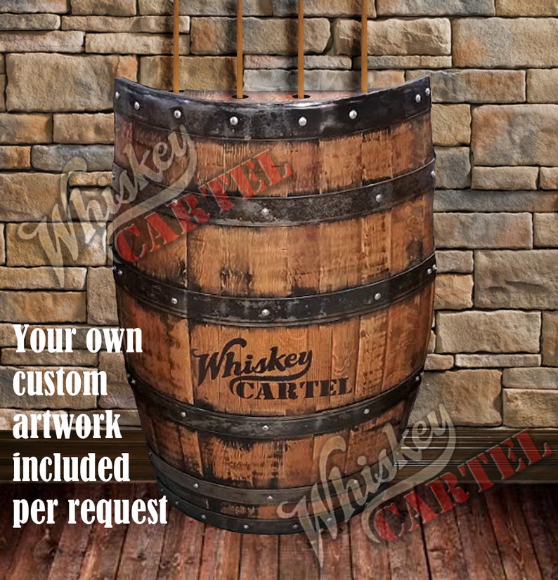 May include: A wooden barrel with metal bands and a whiskey cartel logo. The barrel is mounted on a wall and has three holes in the top for holding items.