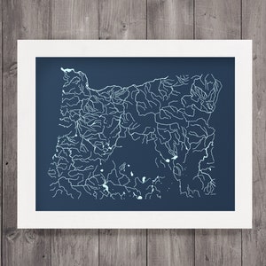 May include: A navy blue framed print of a white line drawing of the river systems of Oregon.