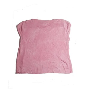 May include: A pink short-sleeved shirt made of a soft, textured fabric.